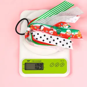 Détail de l'élastique à cheveux avec rubans de Noël multicouches et motifs festifs