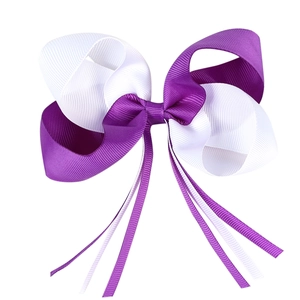 Détail d'un nœud papillon en ruban gros-grain violet et blanc avec de longs rubans