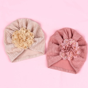Close-up of baby turbans with large 3D fabric flowers and gold foil dots detailing