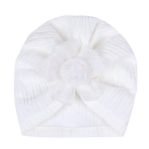 Detailed texture of white ribbed infant turban with a large sequined mesh flower