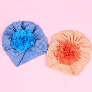 Close-up of baby turban hats with large chiffon flowers and gold foil polka dots