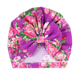 Detailaufnahme der dunkelvioletten Baby-Turban-Mütze mit Blumenmuster und großer Schleife