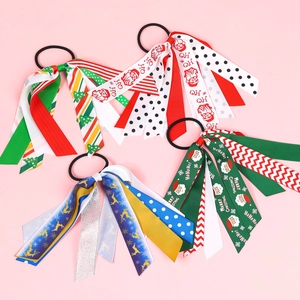 Lot de quatre chouchous de Noël avec motifs Père Noël et rennes sur fond rose clair