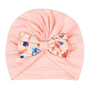 Détail du bonnet turban pour bébé rose avec un grand nœud décoratif à fleurs