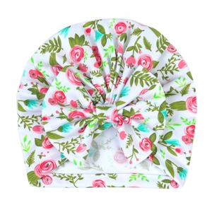 Nahaufnahme der Turbanmütze mit rosa Blumenmuster, großer Schleife und Rippenstruktur