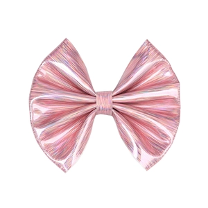 Detailed view of shiny pink bow clip with metallic luster and vertical embossed texture