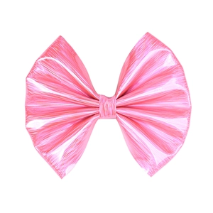 Detailed macro view of a pink glossy leather bow hair clip with a pleated fan texture