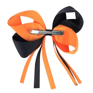 Détail de la pince en métal argenté sur un nœud d'Halloween bicolore orange et noir