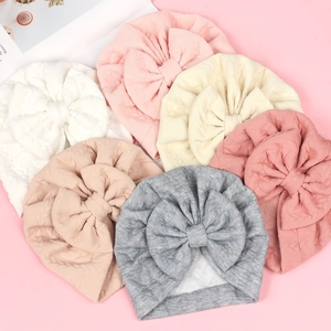 Detailed view of baby turban hats with large bows in six different soft colors