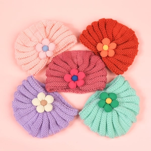 Five assorted colors of winter baby knit hats featuring 3D floral accents for warmth