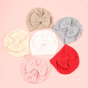 Détails de bonnets tricotés pour bébé avec nœuds en six couleurs et texture nid d'abeille