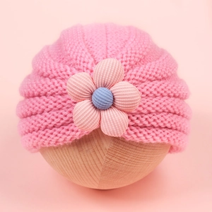Pink knitted baby hat with a striped floral bow, warm winter headwear for infants