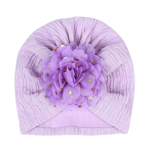 Detail of lavender baby turban hat with textured knit fabric and gold polka dot floral