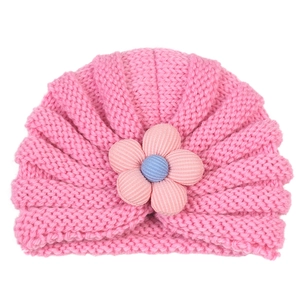 Detail of baby pink knit turban hat with textured five-petal floral 3D ornament