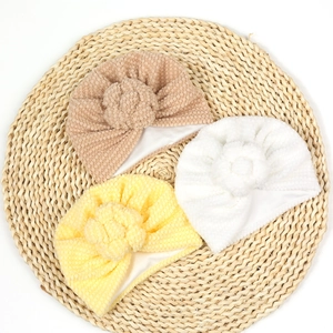 Détails de trois bonnets turban pour bébé en maille popcorn avec fleurs décoratives