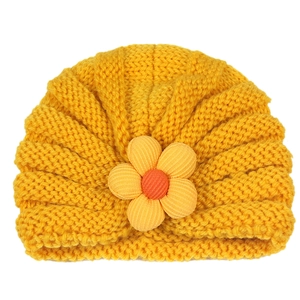 Detailed texture of yellow knit baby turban hat featuring a 3D fabric flower accent