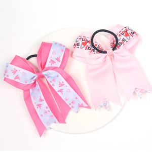 Detail of two-piece bow hair ties with grooved ribbon and red heart patterns for girls
