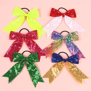 Sparkly sequin bow hair ties in vibrant colors with elastic bands on pink background