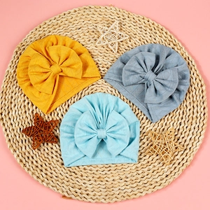 Three-color newborn baby bow turban caps with geometric diamond knit texture on straw mat