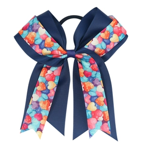 Detail of navy blue ribbon hair tie with colorful heart patterns and elastic band