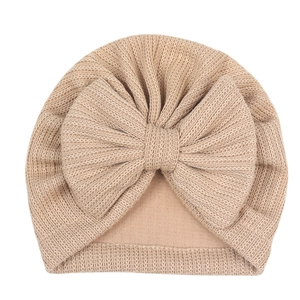 Détail de la casquette tricotée pour bébé avec un grand nœud décoratif à double couche