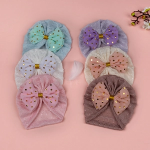Détail de 6 turbans bébé ajourés avec nœuds dorés à pois dans diverses couleurs douces