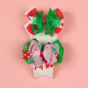Dettaglio di fiocchi di Natale in pizzo con organza verde su espositore rosa
