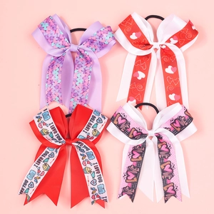 Set of 4 girls' heart-themed ribbon bow hair ties with festive patterns on pink backdrop