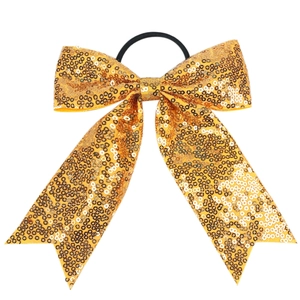 Detail of a sparkling gold sequin bow hair tie with a durable black elastic band