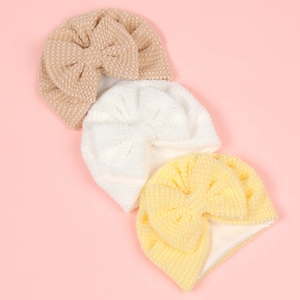 Three-piece set of baby bow headbands with soft popcorn texture in beige, white, and yellow