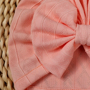Detailed macro view of pink baby headband with diamond mesh knit and bow detail