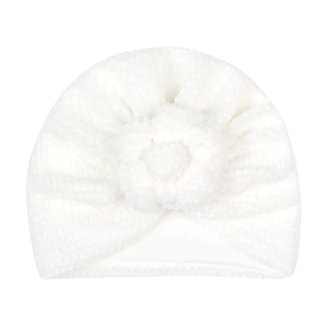 Détail du bonnet turban blanc pour bébé avec fleur en peluche 3D et texture ultra douce