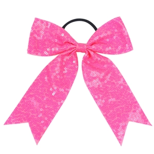 Detail of pink sequin bow hair tie featuring glittery texture and fishtail ribbon design