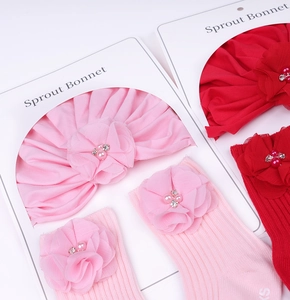 Détail d'un ensemble bonnet à fleurs et chaussettes pour bébé avec perles et strass