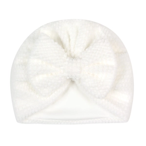 Detail of white newborn infant turban hat featuring soft popcorn knit texture and large bow