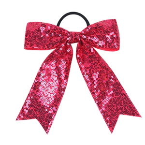 Close-up of bright red sequin bow hair tie with elastic band for girls hair styling