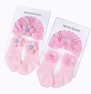 Détail d'un ensemble bandeau et chaussettes rose pour bébé avec fleurs 3D délicates