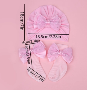Détail de l'ensemble bonnet turban et chaussettes rose pour bébé avec nœuds en strass
