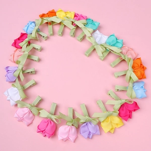 Barrettes à fleurs roses en tissu fait main disposées en forme de cœur sur fond rose