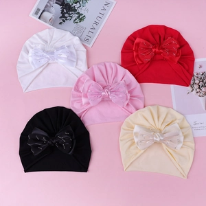 Détail de turbans pour bébé avec de grands nœuds scintillants et tissu en coton doux