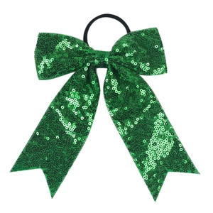 Detail of vibrant green sequin bow hair tie with fishtail ribbons on white background
