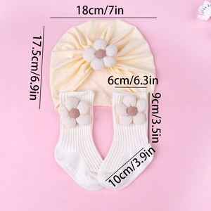 Detail view of cotton baby turban and sock set with 3D floral accents in beige