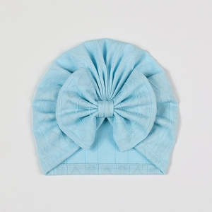 Detailed macro view of the light blue baby hat with hollow diamond texture and large bow