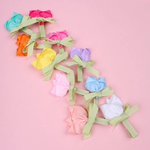 Vue détaillée des barrettes tulipes colorées faites à la main pour filles sur fond rose