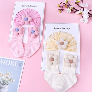 Detailed set of knit baby bonnet and socks with 3D floral accents in pink and beige