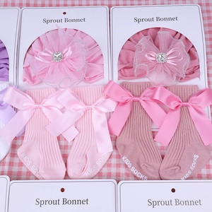 Detailed view of baby headband with mesh flower, rhinestones, and matching bow socks