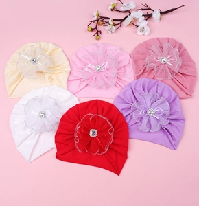 Vue détaillée des turbans pour bébés avec fleurs en dentelle et centre en strass