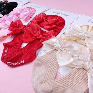 Détail de chaussettes et bandeau en coton pour bébé avec nœuds satin et strass
