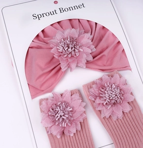 Détail de l'ensemble turban et chaussettes bébé rose poudré avec fleurs en tissu 3D