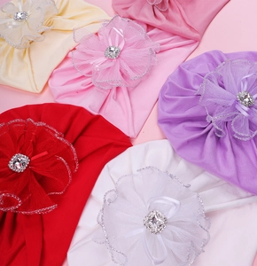 Détail de bonnets turbans pour bébés avec fleurs en résille, rubans et strass carrés